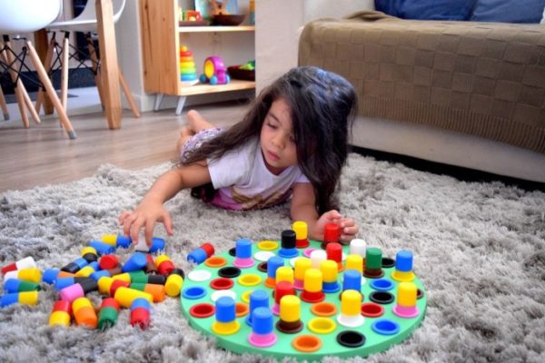 Criança jogando o jogo de encaixar as formas do montessori